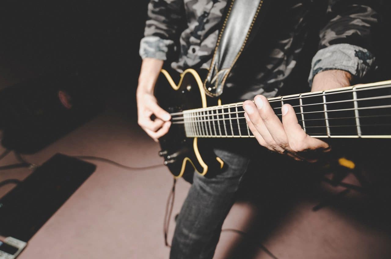 person playing electric guitar on the street